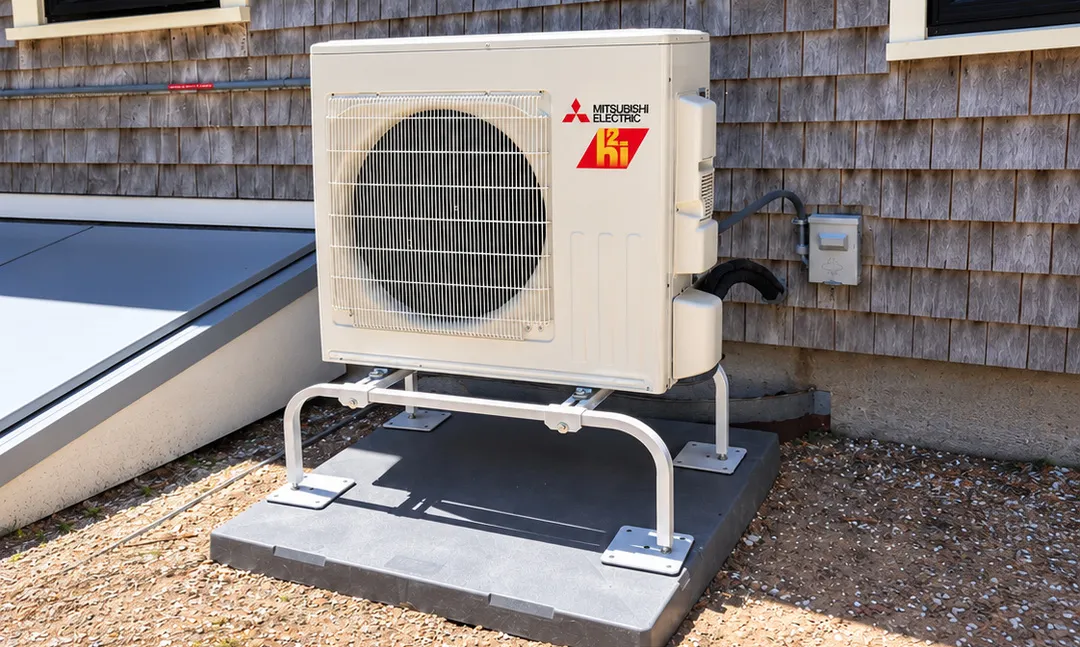 Mitsubishi Electric Hyper-Heat heat pump outdoor unit on raised stand, installed by High Flow HVAC on Cape Cod